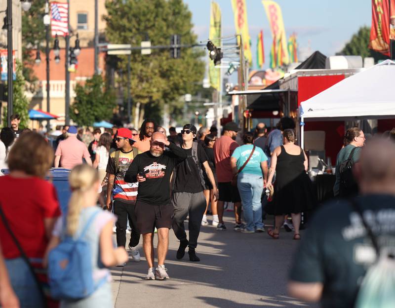 Visitors walk down Lincoln Highway Friday, Aug. 22, 2025, during the first day of Corn Fest in downtown DeKalb.