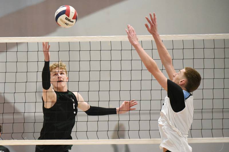 Bishop McNamara's Richie Darr, left, looks to send a hit past Kankakee's Asa Chandler during a game at Kankakee Tuesday, March 31, 2026.