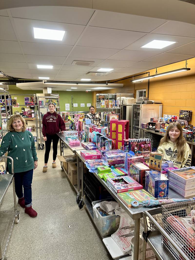 (From left): Genoa-Kingston School District 424 human resources employee and district toy drive organizer Christi Volkening; and students with the high school's Impact Club Madyson King, and Natalie Dodson pose for a photo during the Dec. 18, 2024, toy drive.