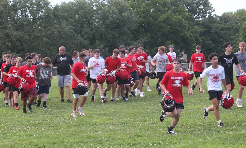 Members of the Hall football team jog off of the field during the first day of football practice on Monday, Aug. 11, 2025 at Hall High School.