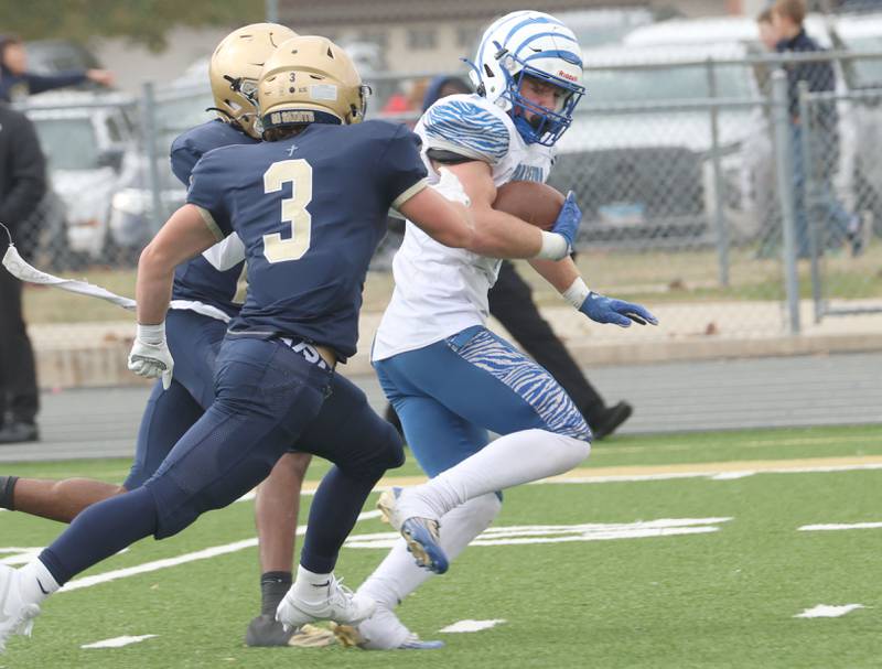 Princeton's Casey Etheridge finds a hole to run the ball down the field as Central Catholic's Connor Rave chases after him during the Class 3A playoffs on Saturday, Nov. 1, 2025 at Central Catholic High School in Bloomington.