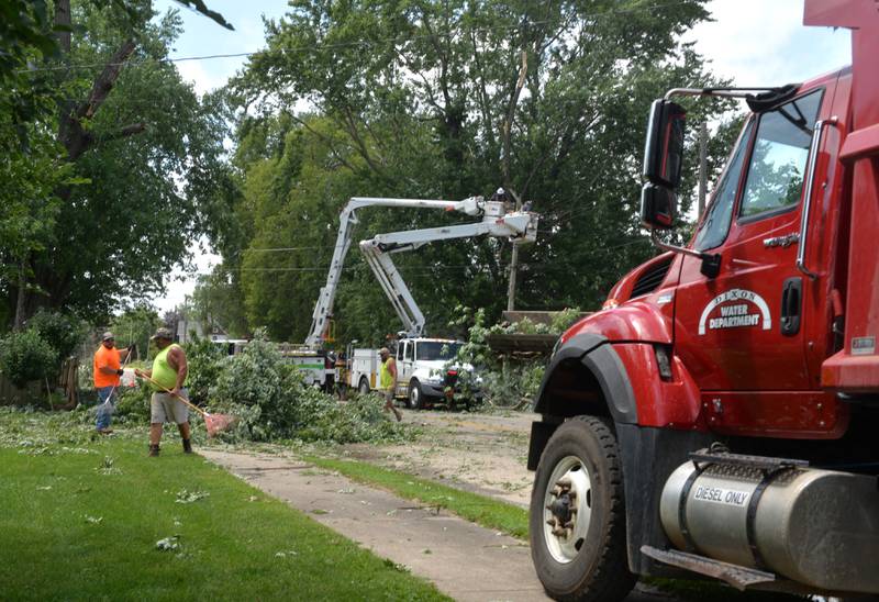 City crews hit the streets in west Dixon to clear trees and branches on Fourth Street that were felled by Friday's early morning as ComEd workers work to repair damaged electrical lines and poles to restore power to residents in the area.