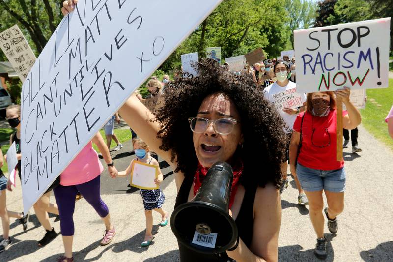 Destiny Dungey of Crystal Lake, 20, holds sign reading "All lives can't matter until black lives matter" while using a megaphone to amplify chants with more than a hundred other protesters who took a stand against racism and the social injustices faced by African Americans across the country during a peaceful Black Lives Matter protest on Saturday, June 6, 2020 in Fox River Grove. The protesters rallied at the soccer fields of Algonquin Road School and marched to Lions Park for speakers.