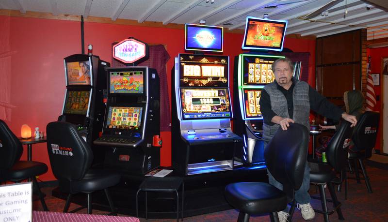 Mike Arians stands by the six video gaming terminals located in The Road House, a bar in Oregon owned by his daughter, Amy Marquis. Arians runs the establishment day-to-day. The Oregon City Council is considering raising the annual fee per terminal from $25 to $250, an increase allowed by a recent change in state law. If the fee is raised, local proprietors would pay half; the company that owns the machines would pay the other $125.