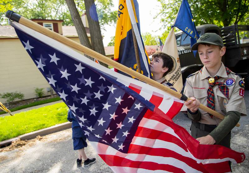 Scout Austin Brochtrup, 10, from Pack 110 unravels an American flag prior to the start of the St. Charles Memorial Day Parade in downtown St. Charles on Monday, May 26, 2025.