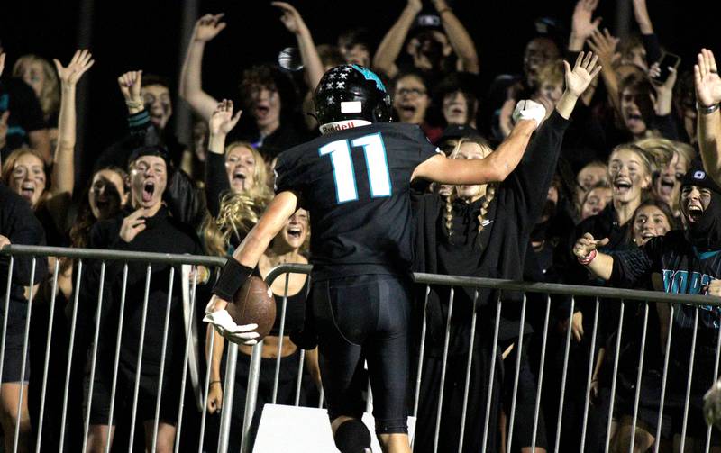 Woodstock North’s Parker Menzel gets the Thunder faithful revved up after scoring a touchdown against Woodstock in varsity football at Woodstock North Friday night.