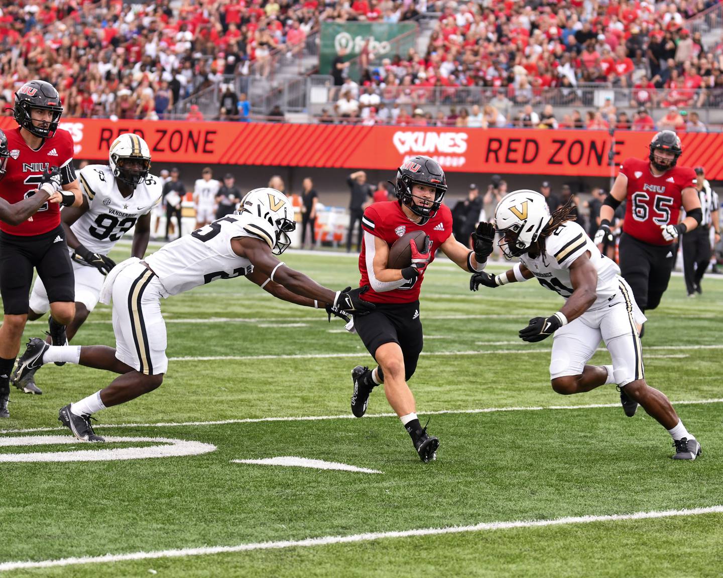 Northern Illinois Kacper Rutkiewicz (8) runs the ball in the second quarter before being brought down by Vanderbilt defenders on Saturday Sep. 17 at Huskie Stadium in DeKalb.
