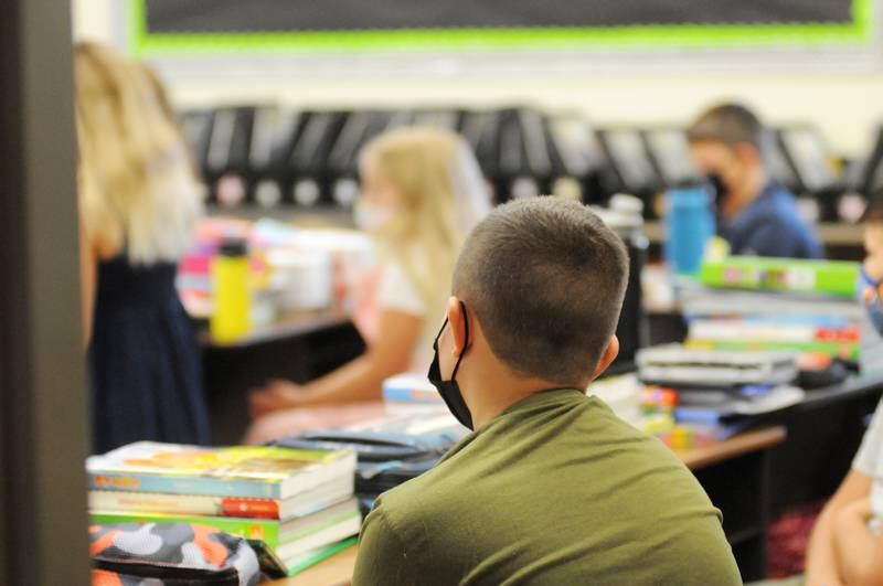 Students listen to their teacher on the first day of school at Grand Ridge Grade School on Wednesday, Aug. 18, 2021.