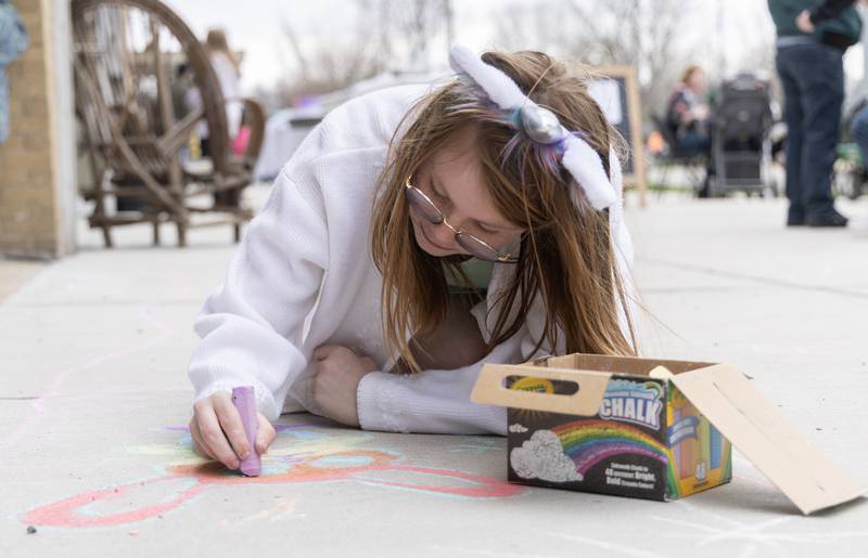 During Saturday, March 30, 2024, afternoon's Hurray for spring celebration in Ottawa, Zaylee Hologa, 9, of Ottawa creates a colorful chalk drawing of a bunny on the Court Street sidewalk.