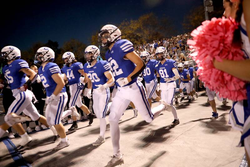 Geneva players run onto the field before a game against Wheaton North on Friday, Oct. 11, 2024 at Geneva.