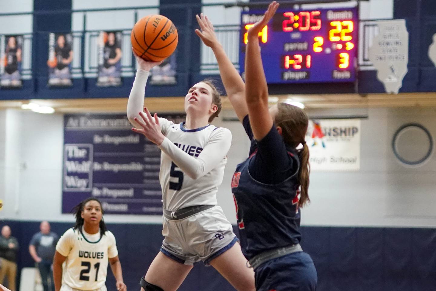 Oswego East's Lillie VanDyke (5) shoots the ball in the post against Oswego’s Kendall Grant (42) during a basketball game at Oswego East High School on Saturday, January 11, 2025.