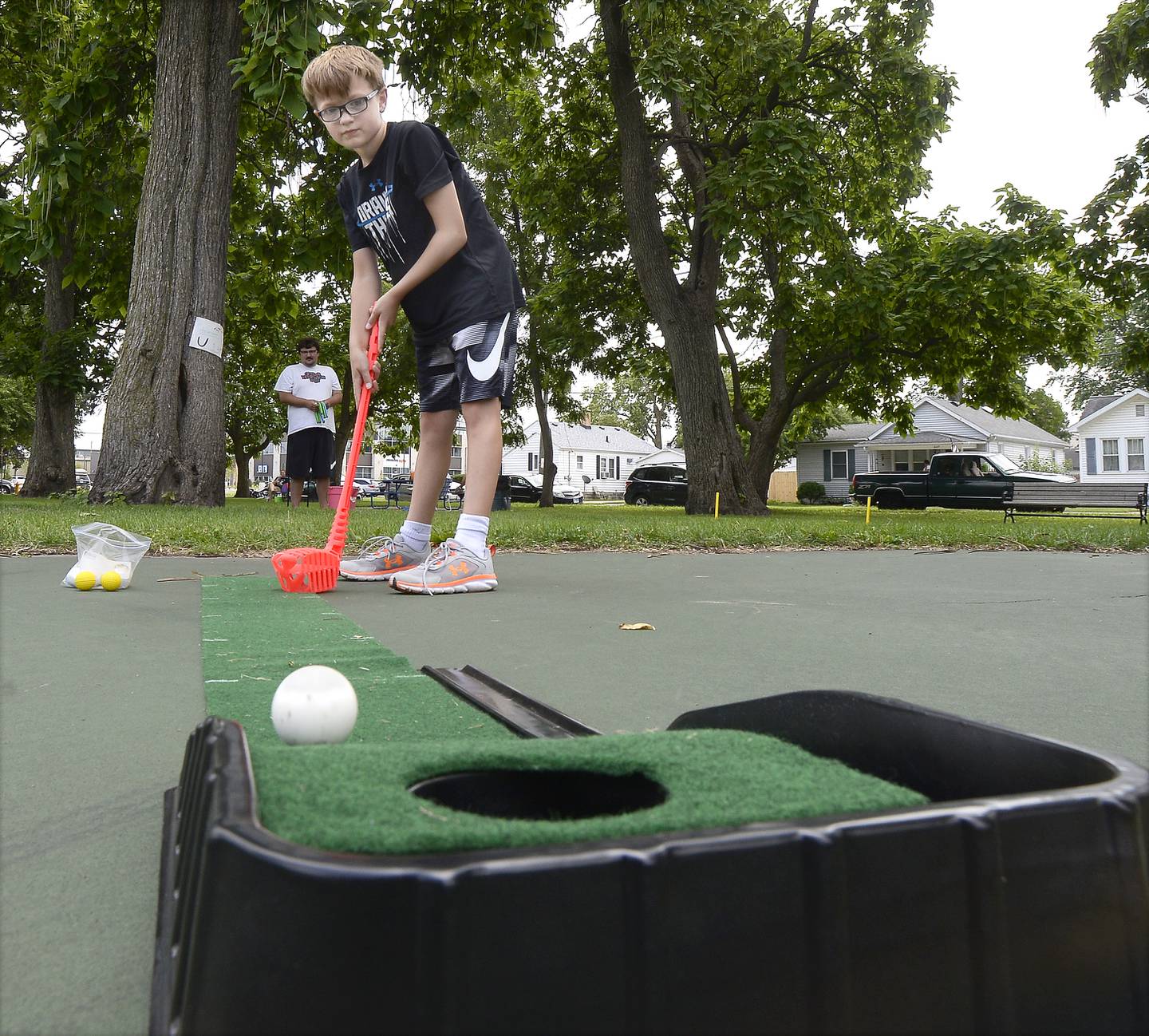 Hunter Heuser sinks this putt while playing mini golf Wednesday, July 27, 2022, at the Ottawa City Recreation game carnival at Rigden Park.