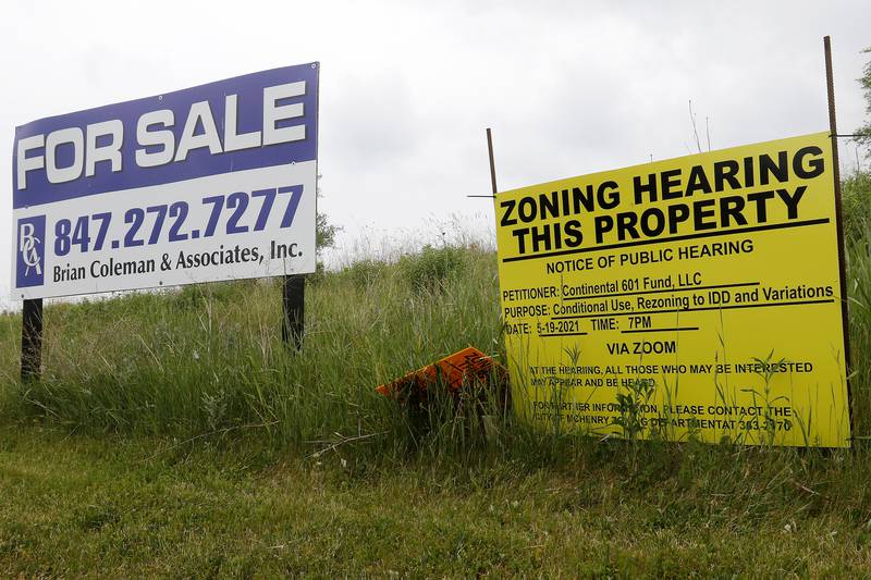 A zoning hearing notice sits next to a for sale sign on property behind Burger King on Monday, June 7, 2021 in McHenry.