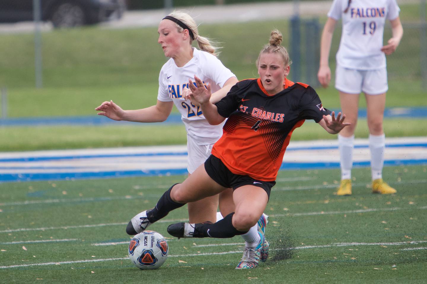 St. Charles East's Grace Williams looks to maintain control of the ball against Wheaton North's Rowan Smith at the Class 3A Regional Final in Wheaton on May 20,2022.