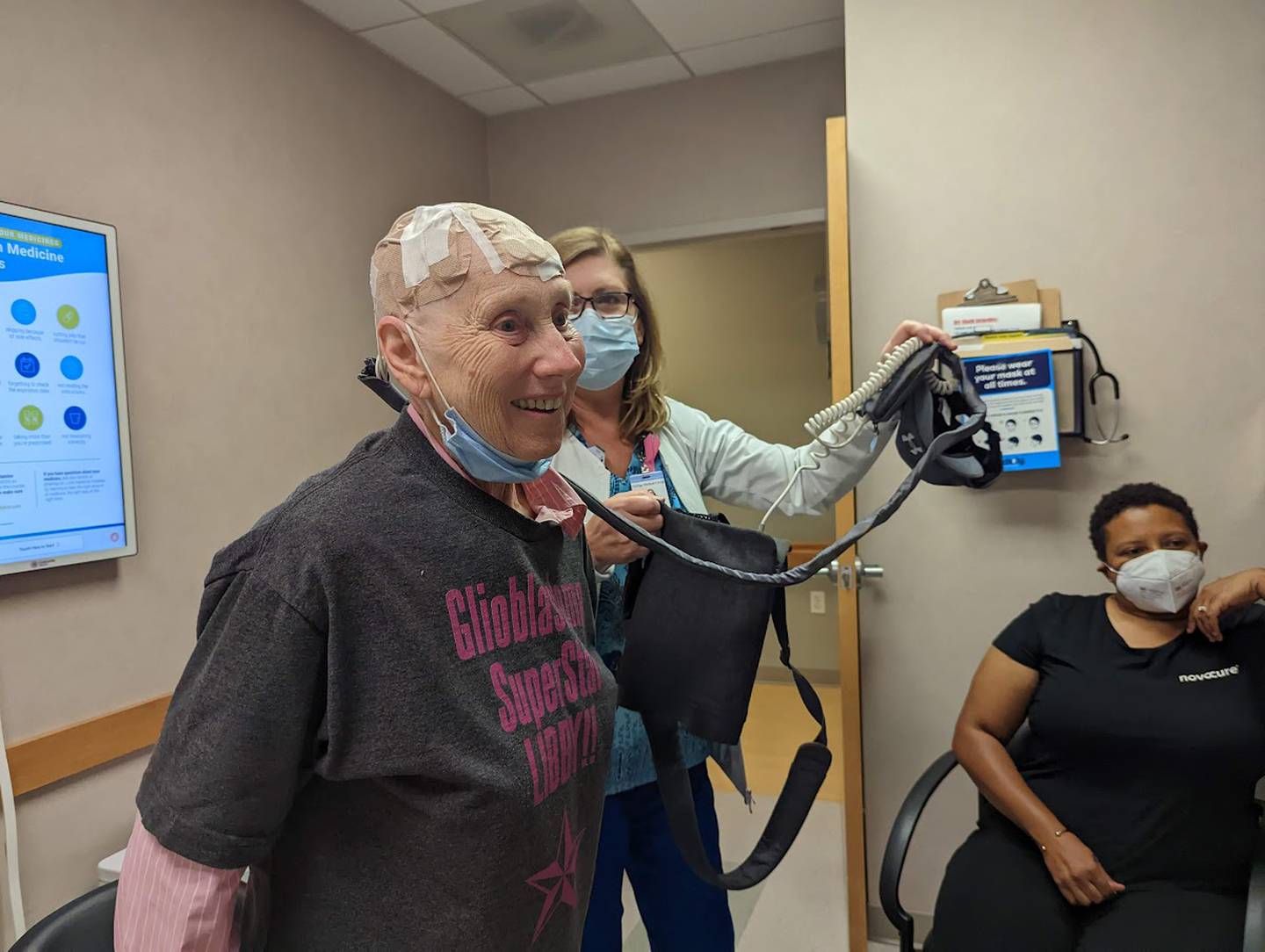 Joan Quaresima, a radiation oncology nurse at Joliet Oncology-Hematology Associates, holds up part of the Optune device after she applied transducer arrays to the scalp of Libby Hall, 75, of Joliet, on Friday, Sept. 16, 2022. Hall was diagnosed with glioblastoma multiform, an aggressive brain cancer, in 2020 and is currently wearing a device called Optune, which delivers an electrical field into the cancer cells in her brain.