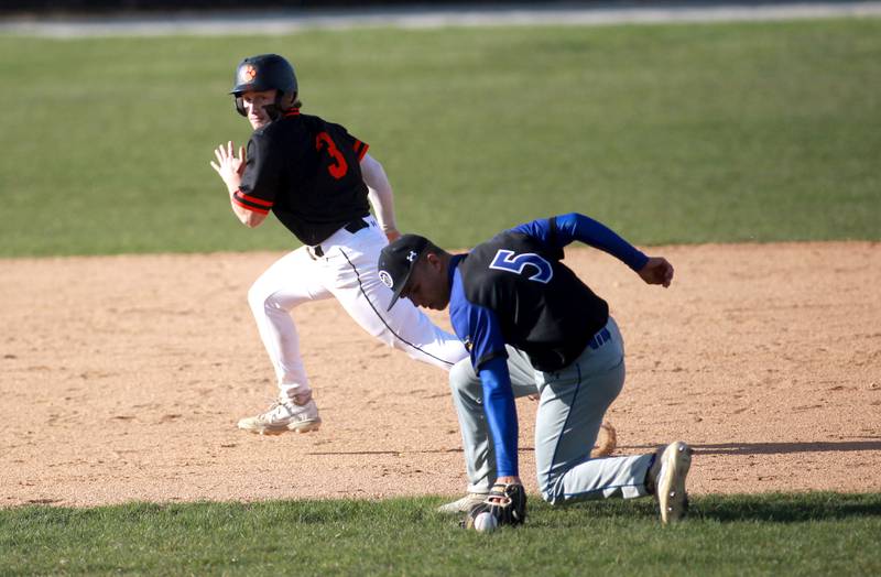 Geneva's Nelson Wendell grabs a ground ball as Wheaton Warrenville South's Nico Olszewski runs to third base during a game on Monday April 14, 2025 in Wheaton.