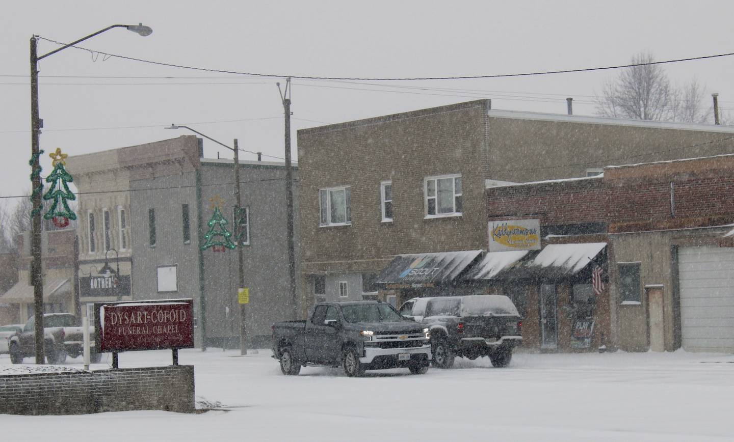 A few trucks navigate an otherwise deserted downtown Granville at 3 p.m. Saturday during the height of the winter storm.