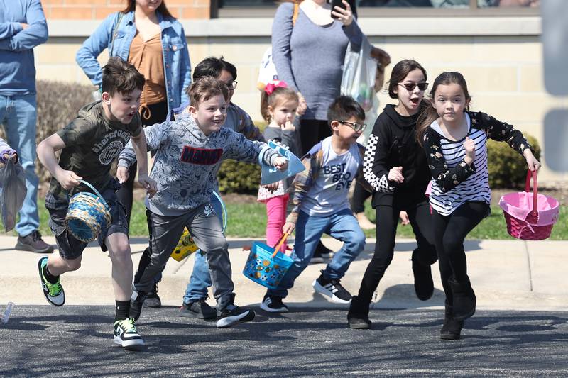 Kids sprint across the parking lot at the start of the Easter egg hunt at The Table’s annual Easter egg hunt on Saturday, April 8, 2023 in Joliet.