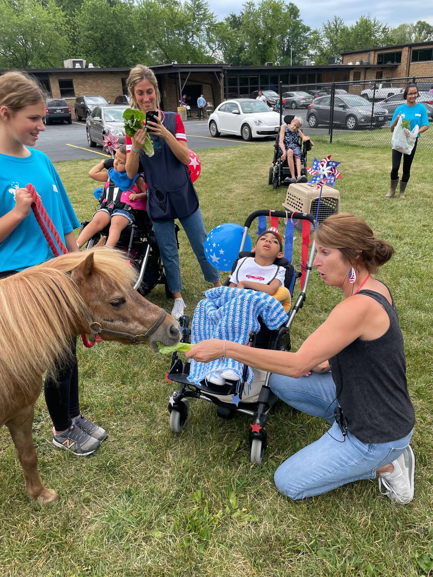 Clients, students and staff at United Cerebral Palsy-Center for Disability Services in Joliet came out to the grassy area near the school to touch and pet the animals and feed the horses romaine lettuce. Volunteers from Ready Set Ride in Plainfield brought the animals.