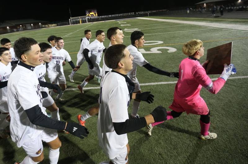 Members of the Mendota boys soccer team run with excitement while carrying the Class 1A Supersectional plaque during the Class 1A Supersectional game on Monday, Nov. 3, 2025 at Mendota High School.