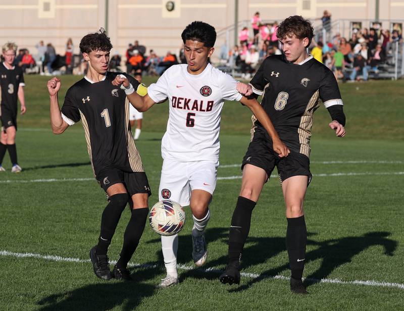 DeKalb's Mauricio Jasso goes between Sycamore's Noah Daykin (left) and Tyler Hiland during the El Classicorn rivalry game Tuesday, Oct. 7, 2025, at Sycamore High School.
