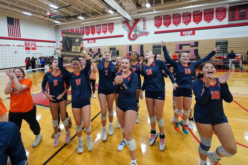 Oswego’s Ava Flanigan (12) hold up the regional championship plaque after defeating Yorkville in two sets to win the Class 4A Yorkville Regional final at Yorkville High School on Thursday, Oct. 31, 2024.