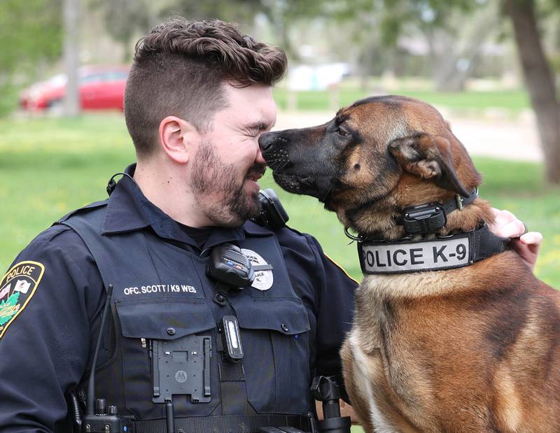 Sycamore Police K-9 officer Greyson Scott gets some attention from his Belgian malinois Wes Thursday, April 18, 2024, at the Sycamore Forest Preserve.