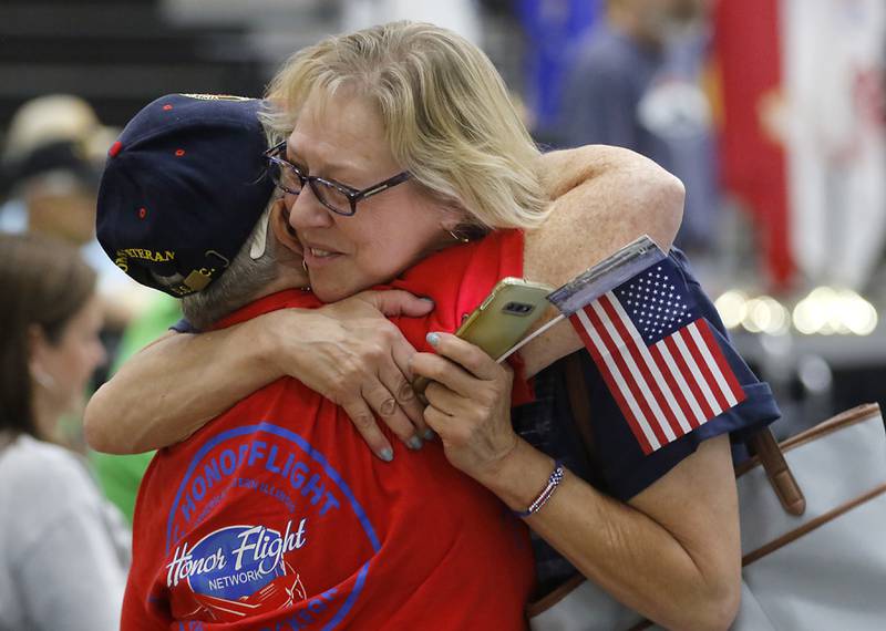 U.S. Marine Corps veteran Mel Brocato is hugged by Chris Coil on Sunday, Aug. 27, 2023, during a celebration for veterans returning from an Honor Flight trip to Washington D.C.