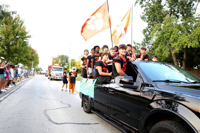 Wheaton Warrenville South football players ride in a truck during the school’s annual homecoming parade on Wednesday, Sept. 11, 2024 on Weisbrook Road in Wheaton.