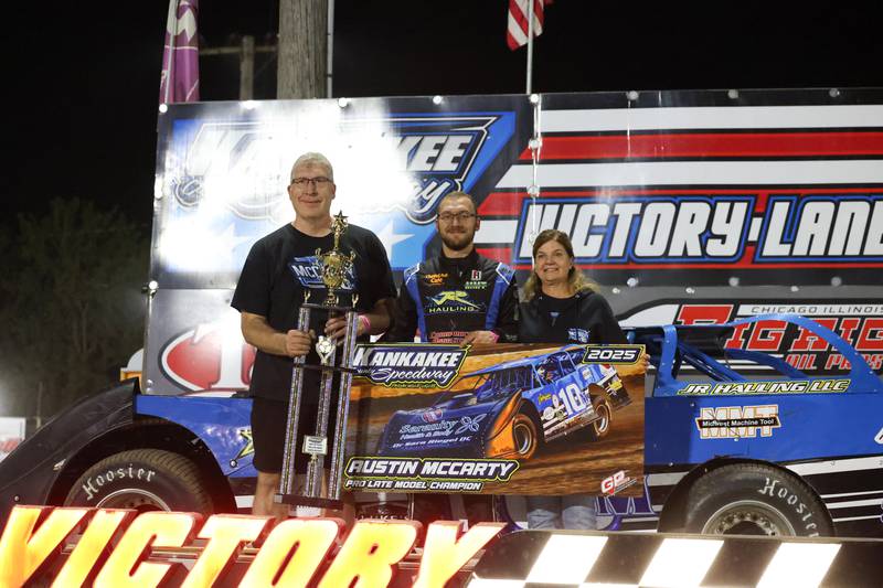 Austin McCarty, center, stands with his parents Steve, left, and Julie McCarty, as he is awarded the Pro Late Model class champion trophy on Friday, Sept. 26, 2025, at the Kankakee County Speedway. McCarty won the title for the second year in a row, earning the McCarty family's 10th overall title following a bittersweet racing season.