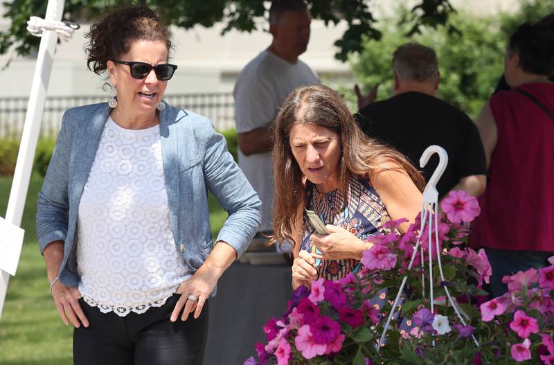 Michelle Farley, (left) from DeKalb, and Michelle Copple, from Sycamore, look at flowers at the Roden's Elegant Gardens booth Tuesday, June 7, 2022, at the Sycamore Farmers Market on the lawn of the DeKalb County Courthouse.