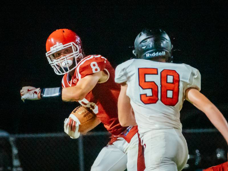 Braden Curran of Hall pushes ball towards end zone whilst being guarded by Anthony Dochterman of Orion on Friday, August 30, 2024 at Richard Nesti Stadium in Spring Valley.