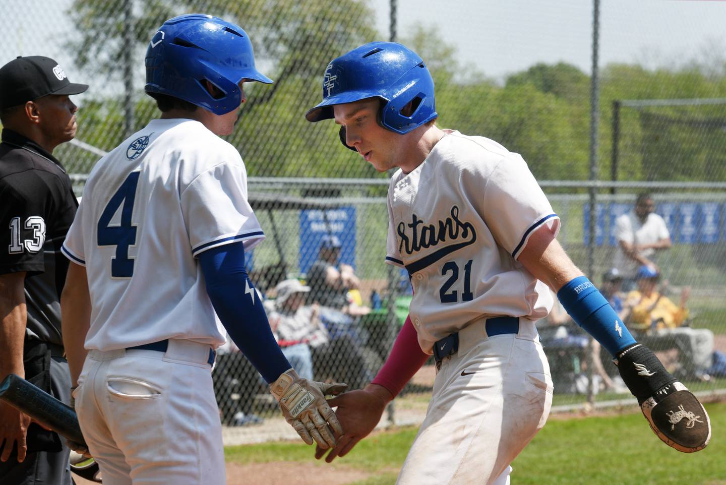 St. Francis’ Nolan Galla, right, is greeted at the plate by Colt Armbrust while scoring the bottom of the third inning of Saturday’s game against Marmion.