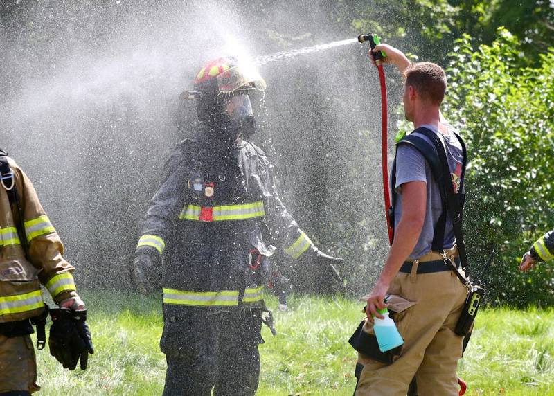 A firemen gets a soaking after the house fire on 200 West Clark St. in Princeton on Friday, July 28, 2023.