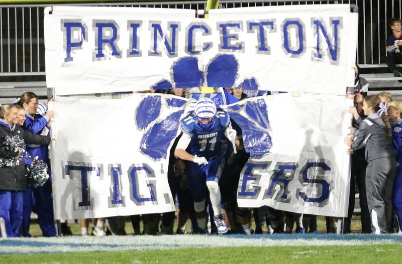 Princeton's Noah LaPorte blasts through the Princeton Tigers sign before the Class 3A playoff game against Oregon on Friday, Nov. 1, 2024 at Princeton High School.