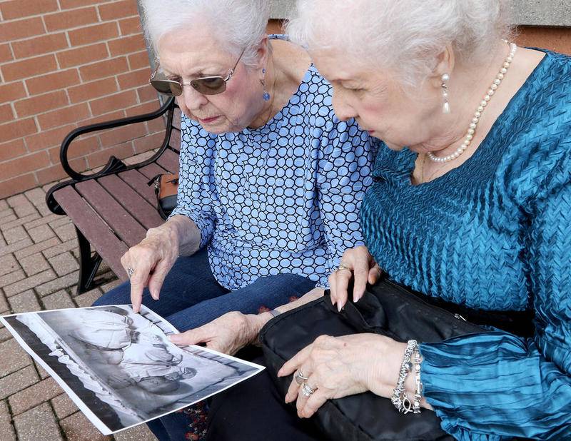 Jean Harrison of Algonquin and Jane Umbarger of McHenry, right, known as the "incubator twins", look at a photo of their infancy as they talk about their experiences on Tuesday, Aug. 21, 2018 in McHenry. The twin sisters, both 84, were among hundreds of premature infants who were placed in incubators at the Century of Progress expo in Chicago in 1933 and 1934.  They also had a double wedding in 1953, which drew national attention.  The sisters are featured in a new book by Dawn Raffel, titled "The Strange Case of Dr. Couney: How a Mysterious European Showman Saved Thousands of American Babies."