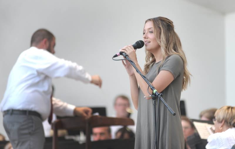 Bailee Fyock of Forreston sings a solo at the Kable Concert Band on Wednesday, July 23, 2025 in Mt. Morris as Travis Cunningham, conducts. Cunningham, the music/band teacher for Forreston High School and Junior High, was the guest conductor for evening concert. Fyock sang "For Good" from Wicked and "Let it Go" from Frozen.