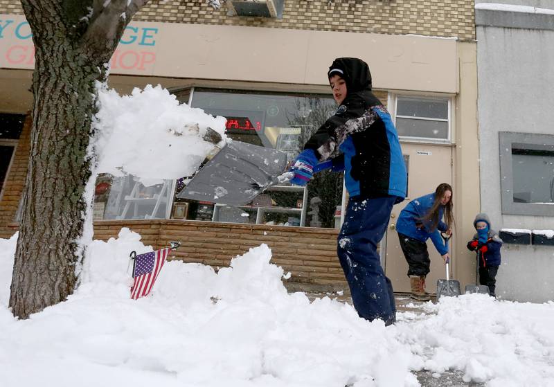 Lucas Ryman, his mom Michelle and brother Alexander shovel snow in front of their business Country Cottage on Wednesday, Jan. 25, 2023 in La Salle. The boys took a snow day and helped their mom shovel the sidewalk in front of the family business.