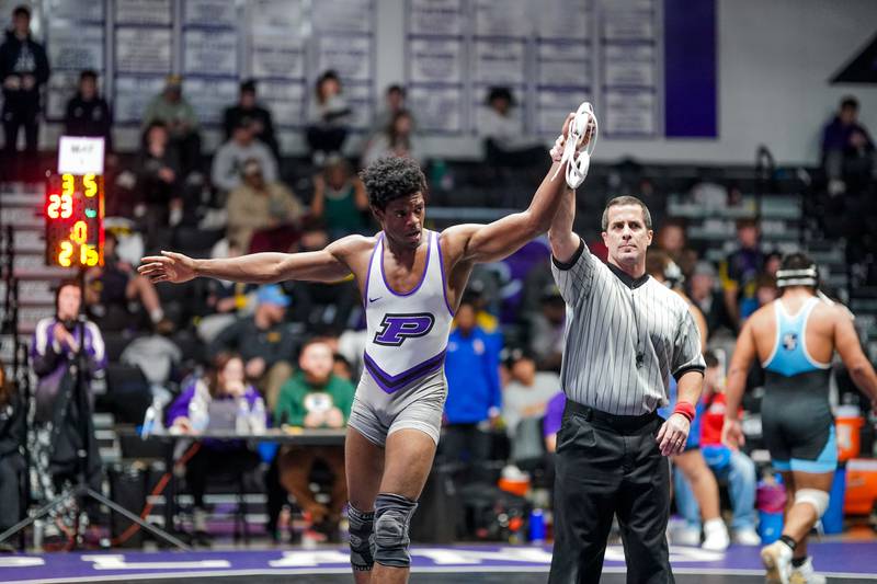 Plano’s Richie Amakiri raises his hands in victory after defeating Marquette Peru’s Alex Schaefer in their 215 pound championship bout in the Plano Reaper Classic Wrestling meet at Plano High School on Saturday, Dec. 14, 2024.