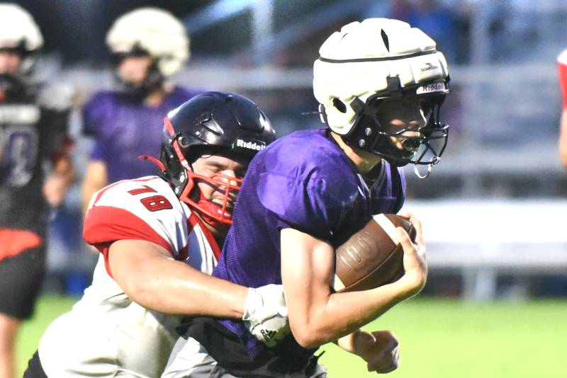 Manteno's Nick Honkisz, right, is wrapped up by Momence's Josh Garcia during scrimmage action at Manteno Thursday, July 24, 2025.