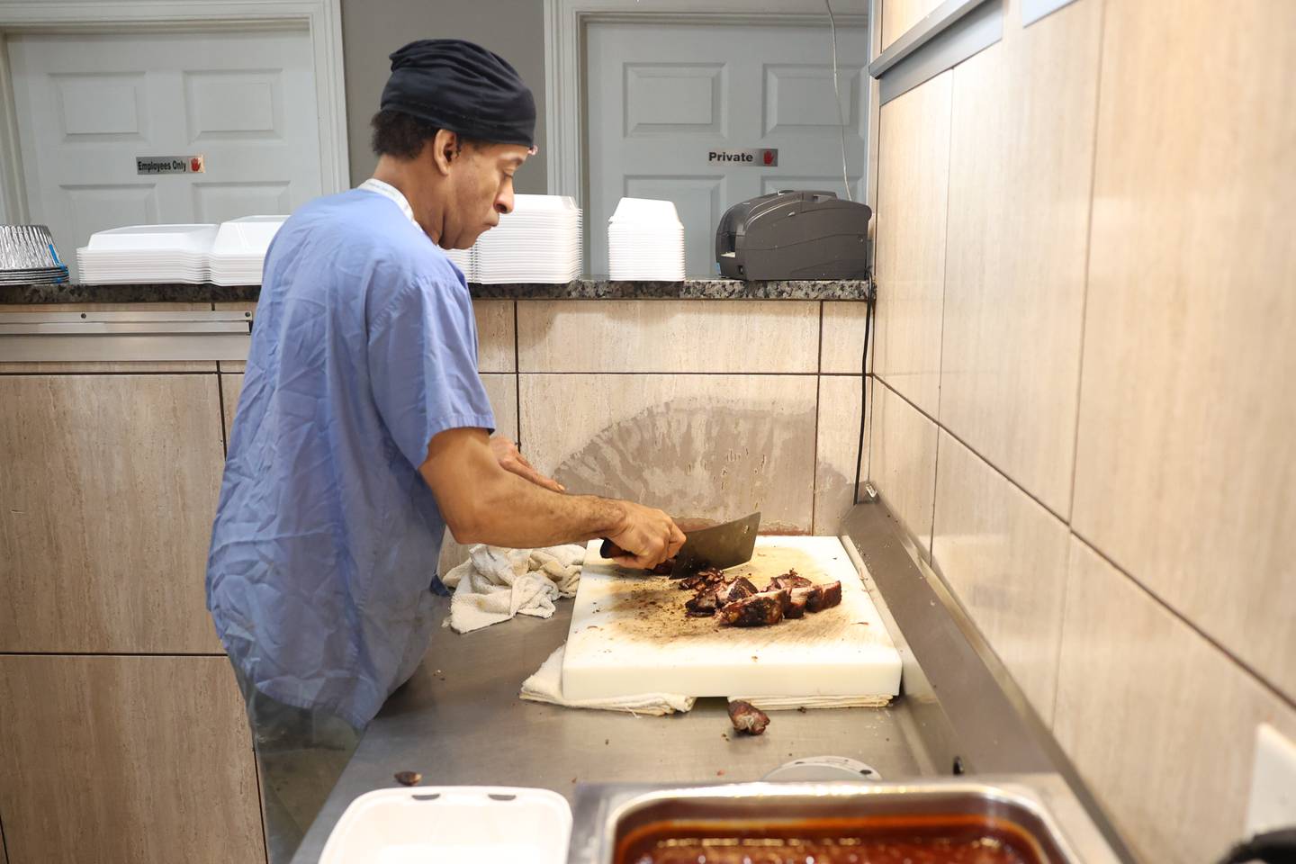 Kevin Roberts cuts up rib tips for an order at Chicago Style BBQ on Wednesday, May 29, 2024 in Joliet.