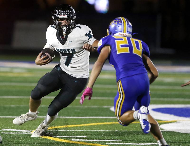 Woodstock North's Parker Halihan tries to avoid \jb20 as he runs with ball during a Kishwaukee River Conference football game on Friday, Sept. 26, 2025, at Johnsburg High School.