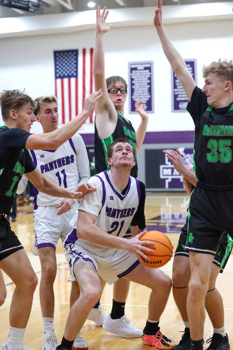 Manteno's Mitchell Boyd looks to shoot a rebound as Bishop McNamara defenders close in during the Fightin' Irish's 61-24 victory over Manteno on Tuesday, Jan. 13, 2026.