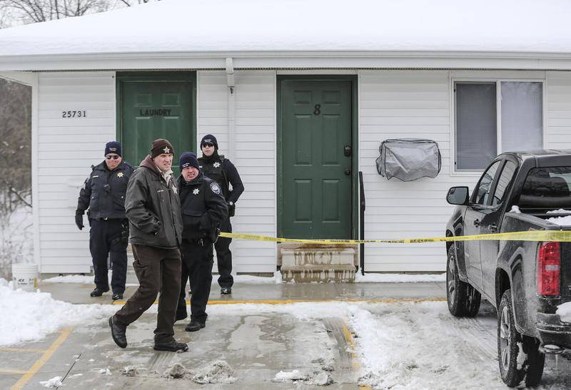 Investigators search through an apartment Tuesday, Feb. 13, 2018, after a body was discovered in Channahon, Ill.
