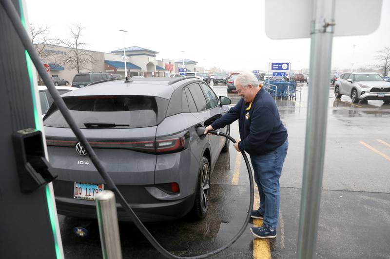 Terry Carden of Plainfield connects his car to one of eight DC fast-charging Electrify America stations at Meijer in Oswego.