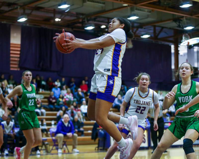 Downers Grove North's Kaitlyn Parker (24) grabs a rebound during basketball game between York at Downers Grove North. Dec 19, 2023.