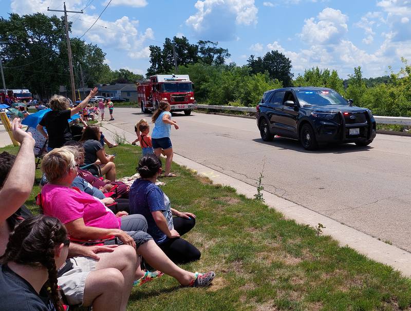 Parade goers welcome the Marseilles Police Department and chase candy to open the Fun Days parade on Sunday, July 9, 2023.