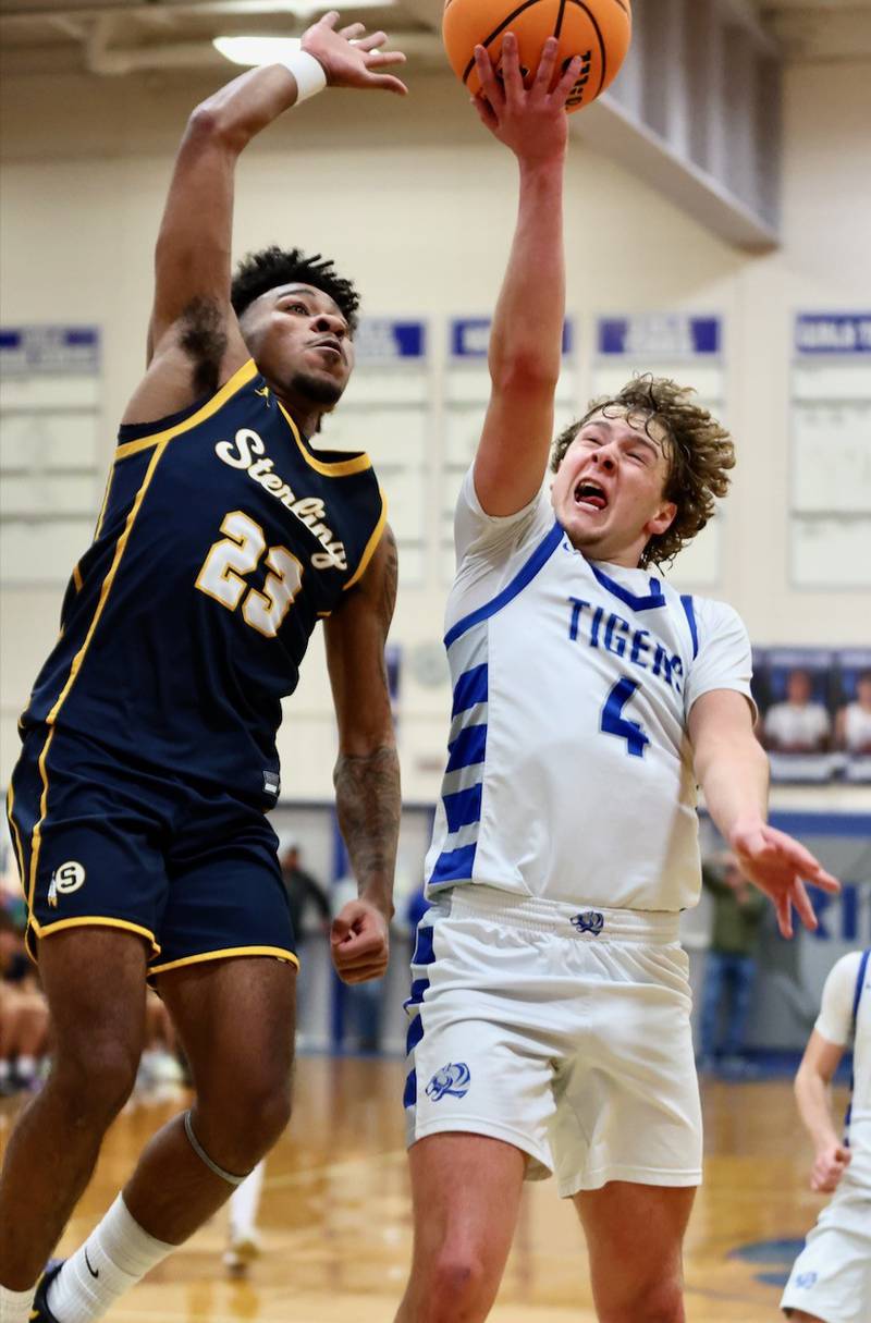 Sterling's Kaedon Phillips tries to block a shot by Princeton's Jayden Fulkerson Friday night at Prouty Gym. The Tigers won 56-47.