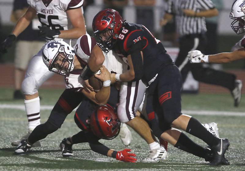 Prairie Ridge's Luke Vanderwiel fights for extra yards as Huntley's Colin Kalemba (center) and Ethan Albertson (right) trie to tackle Vanderwiel during a Fox Valley Conference football game on Friday, Sept. 20, 2024, at Huntley High School.