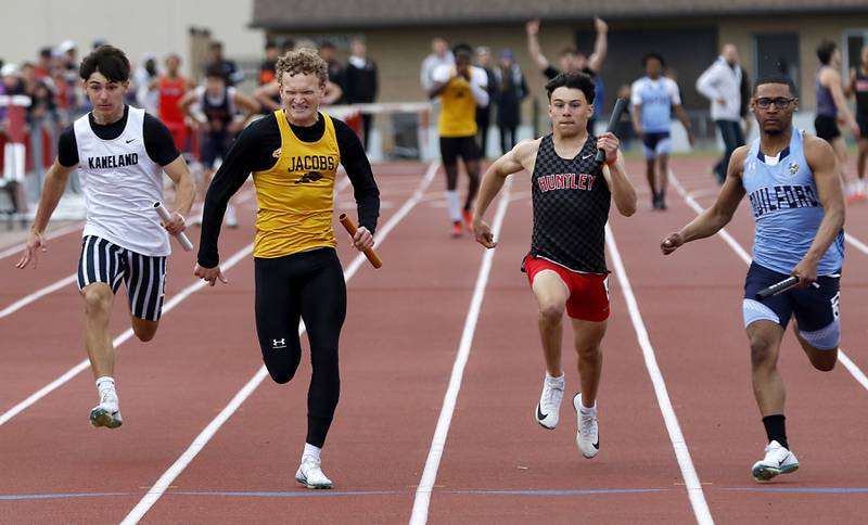 Kaneland’s Luke Gadomski, Jacobs’ Jackson Cook, Huntley’s Noah Van De Voorde, and Gilford’s Alexander Perry race to the finish Lin as they run the final leg of the 4 x 100 meter relay during the Huntley IHSA Class 3A Boys Sectional Track and Field Meet on Thursday, May 22, 2025, at Huntley High School.